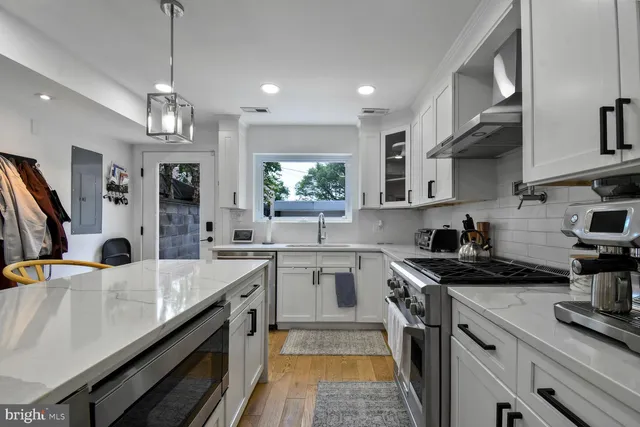 a kitchen with stainless steel appliances a sink stove and cabinets