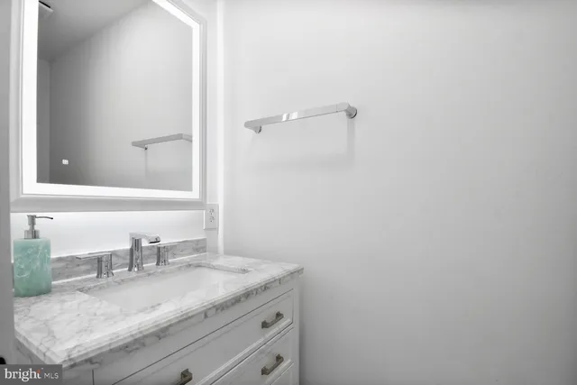 a bathroom with a granite countertop sink and a mirror