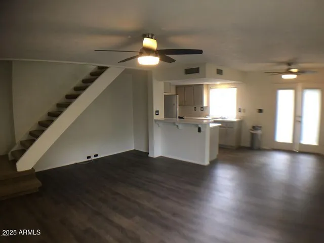 a view of a kitchen with a fridge and wooden floor