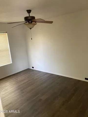 a view of a room with wooden floor cabinet and a ceiling fan
