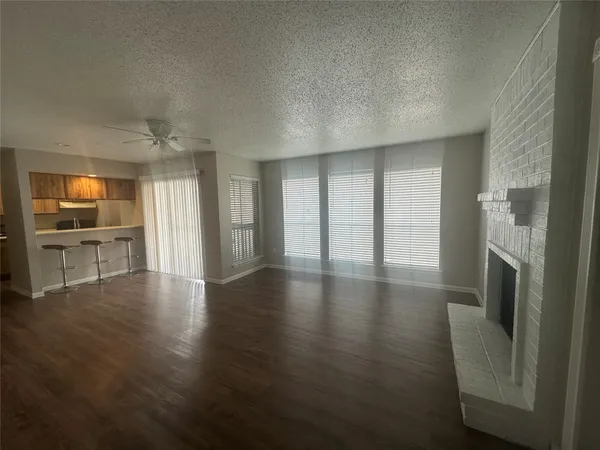an empty room with wooden floor and a fireplace