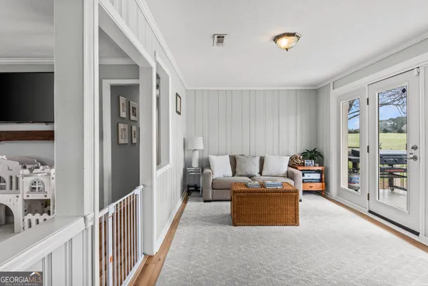 a bedroom with a large bed a chandelier and windows