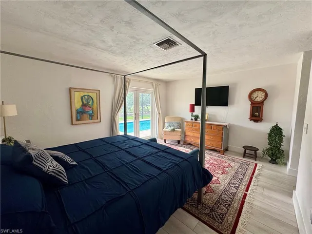 a bed sitting in a bedroom and a flat screen tv