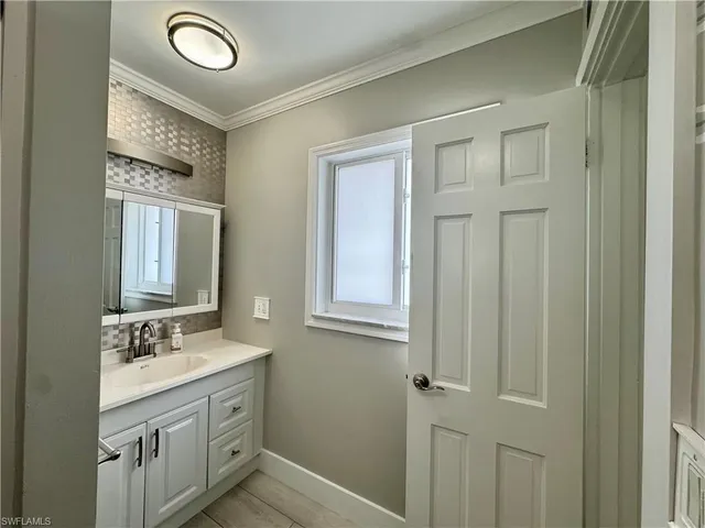 a bathroom with a double vanity sink a mirror and a window