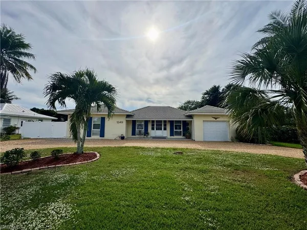 a house with a big yard and palm trees