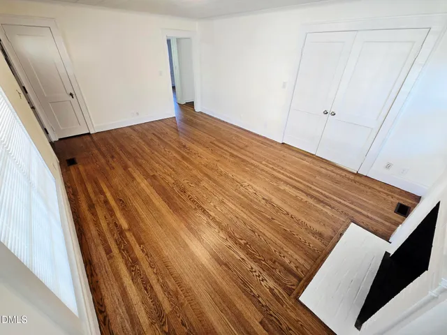 a view of an empty room with wooden floor
