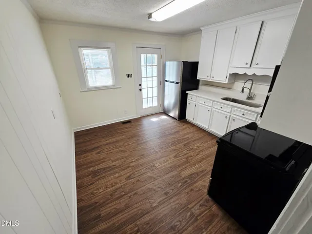 a view of a kitchen with flat screen tv and refrigerator