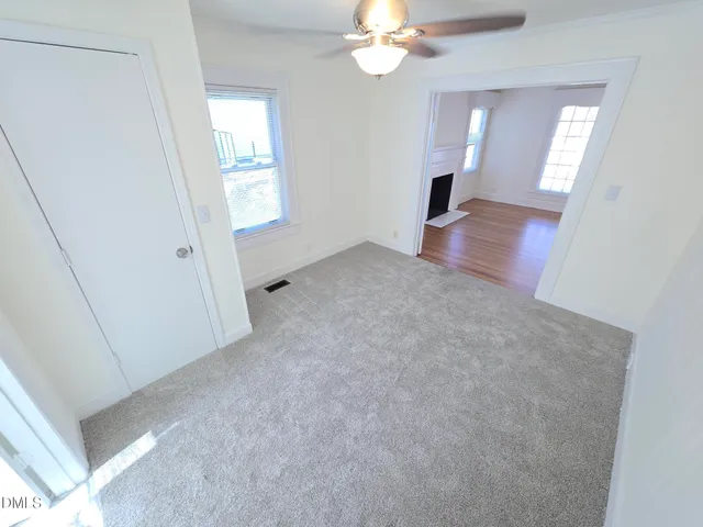 an empty room with windows and hardwood floor