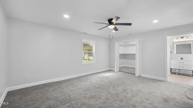 a view of empty room with a ceiling fan and window