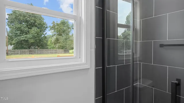 a bathroom with a window and a shower