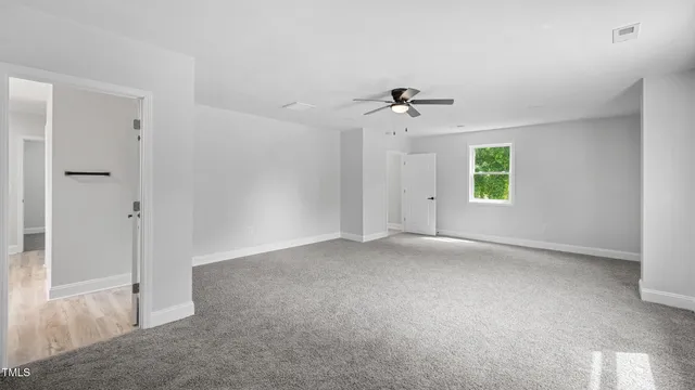 a view of a big room with chandelier fan and windows