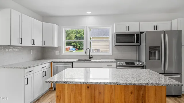 a kitchen with stainless steel appliances granite countertop a sink a stove and a granite counter tops