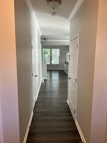 a view of a hallway with wooden floor and staircase