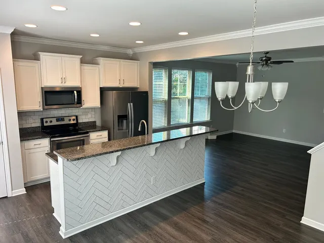 a kitchen with stainless steel appliances a refrigerator a stove top oven and cabinets