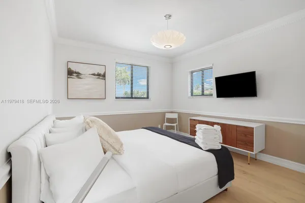 a bedroom with a bed and a flat screen tv