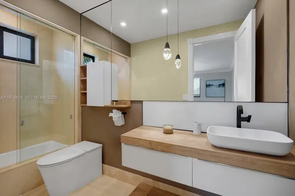 a bathroom with a granite countertop sink toilet and shower