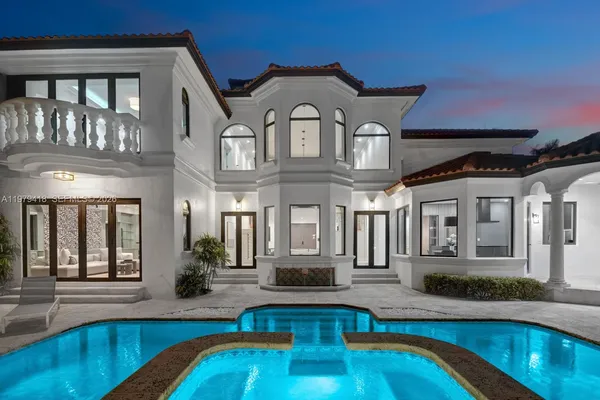 a front view of a house with swimming pool and porch