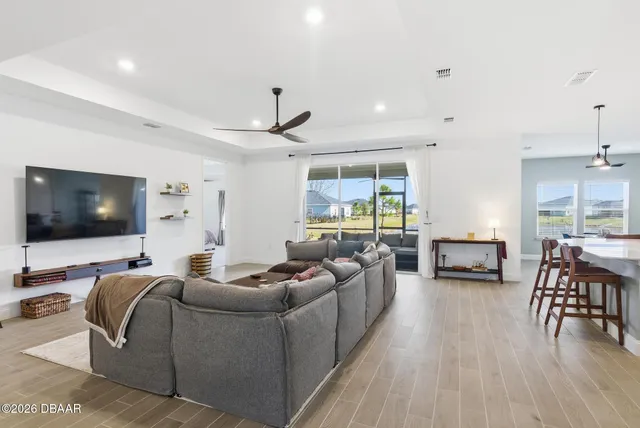 a kitchen with stainless steel appliances a refrigerator a sink a stove a dining table and chairs