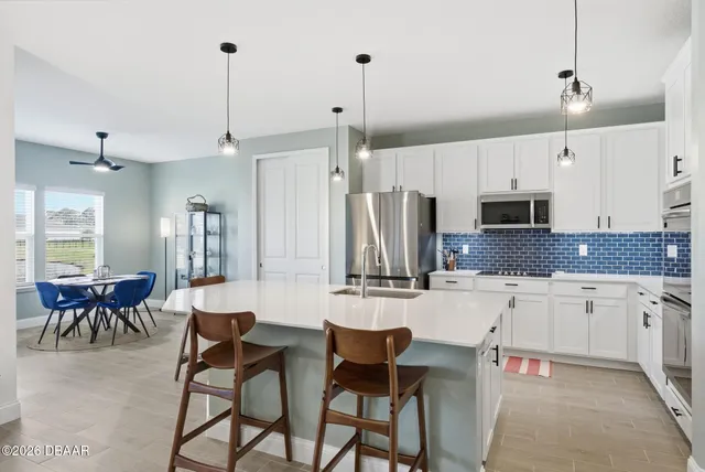 a large white kitchen with a stove a sink and a refrigerator