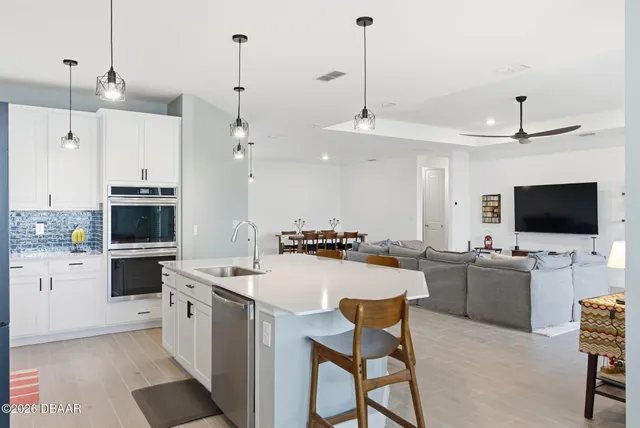 a spacious bedroom with a bed a chandelier and a window