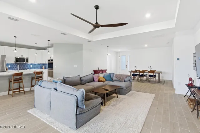 a kitchen with stainless steel appliances kitchen island granite countertop a table chairs and a refrigerator