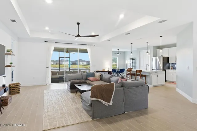 a kitchen with stainless steel appliances kitchen island granite countertop a table chairs and a refrigerator