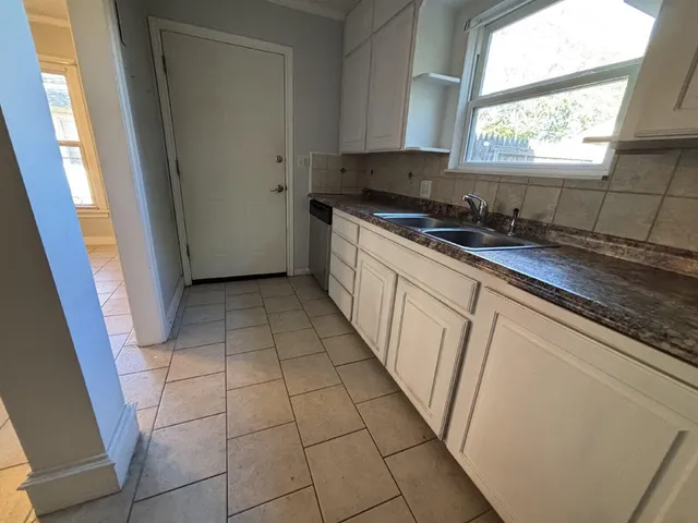 a kitchen with a sink a window and cabinets