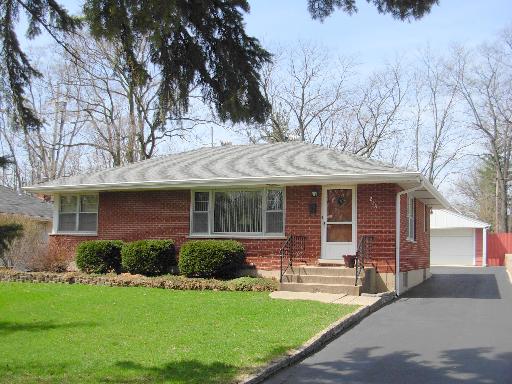 a front view of a house with a garden and yard