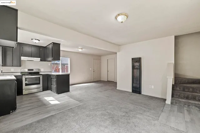 a view of kitchen with refrigerator and stove