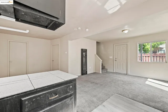 a view of a room with a large window and front door