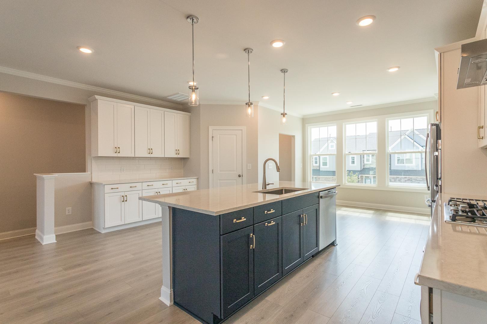 8421 Zinc Autumn Path Raleigh, NC 27615 - Photo 27 of 33 a large kitchen with stainless steel appliances granite countertop a lot of counter space and wooden floors
