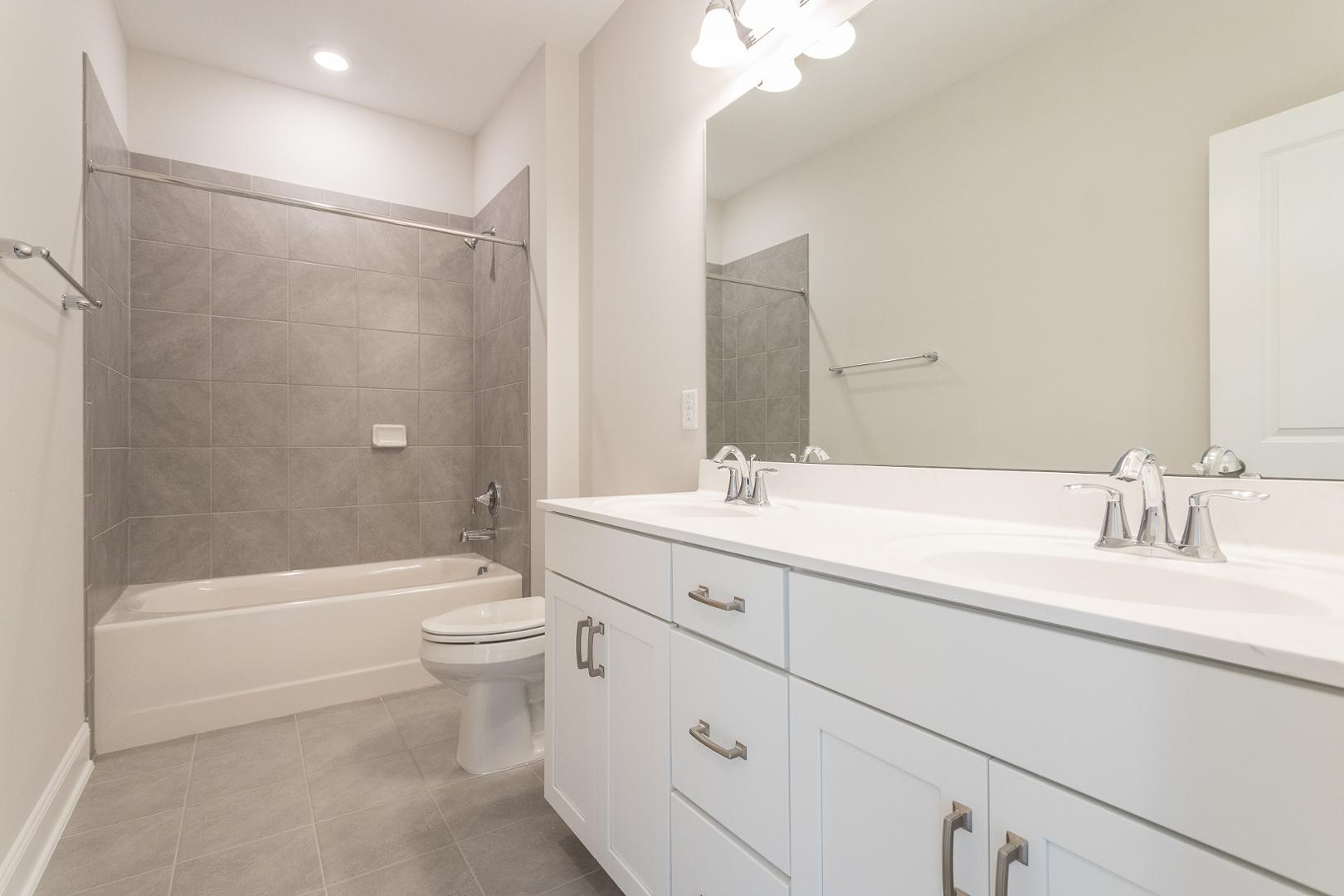 8421 Zinc Autumn Path Raleigh, NC 27615 - Photo 8 of 33 a bathroom with a double vanity sink toilet mirror and bathtub