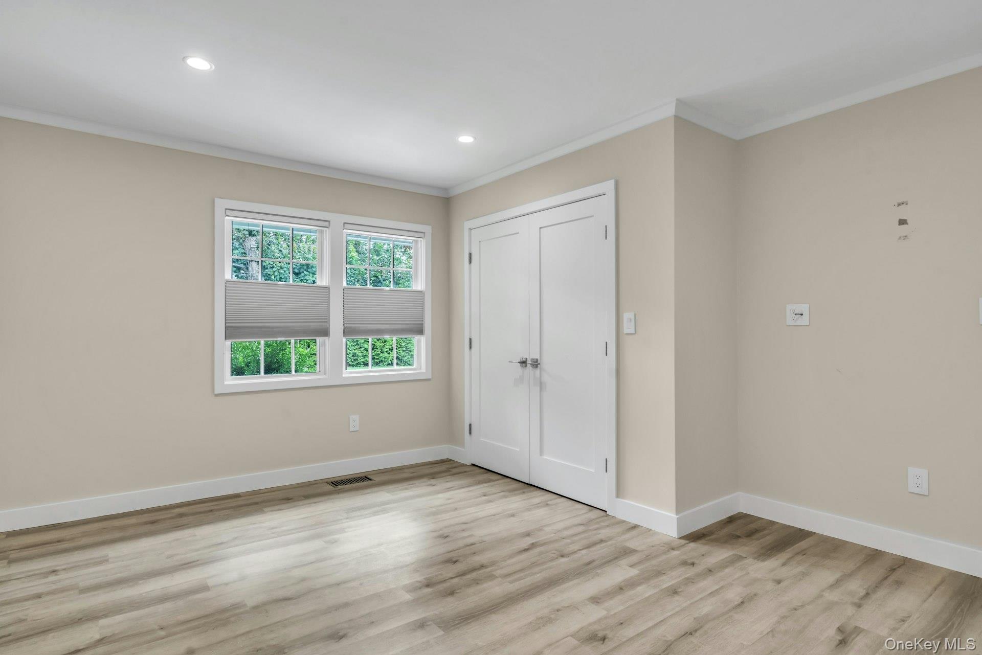 20 Robert Road Glen Cove, NY 11542 - Photo 11 of 24 an empty room with wooden floor and windows
