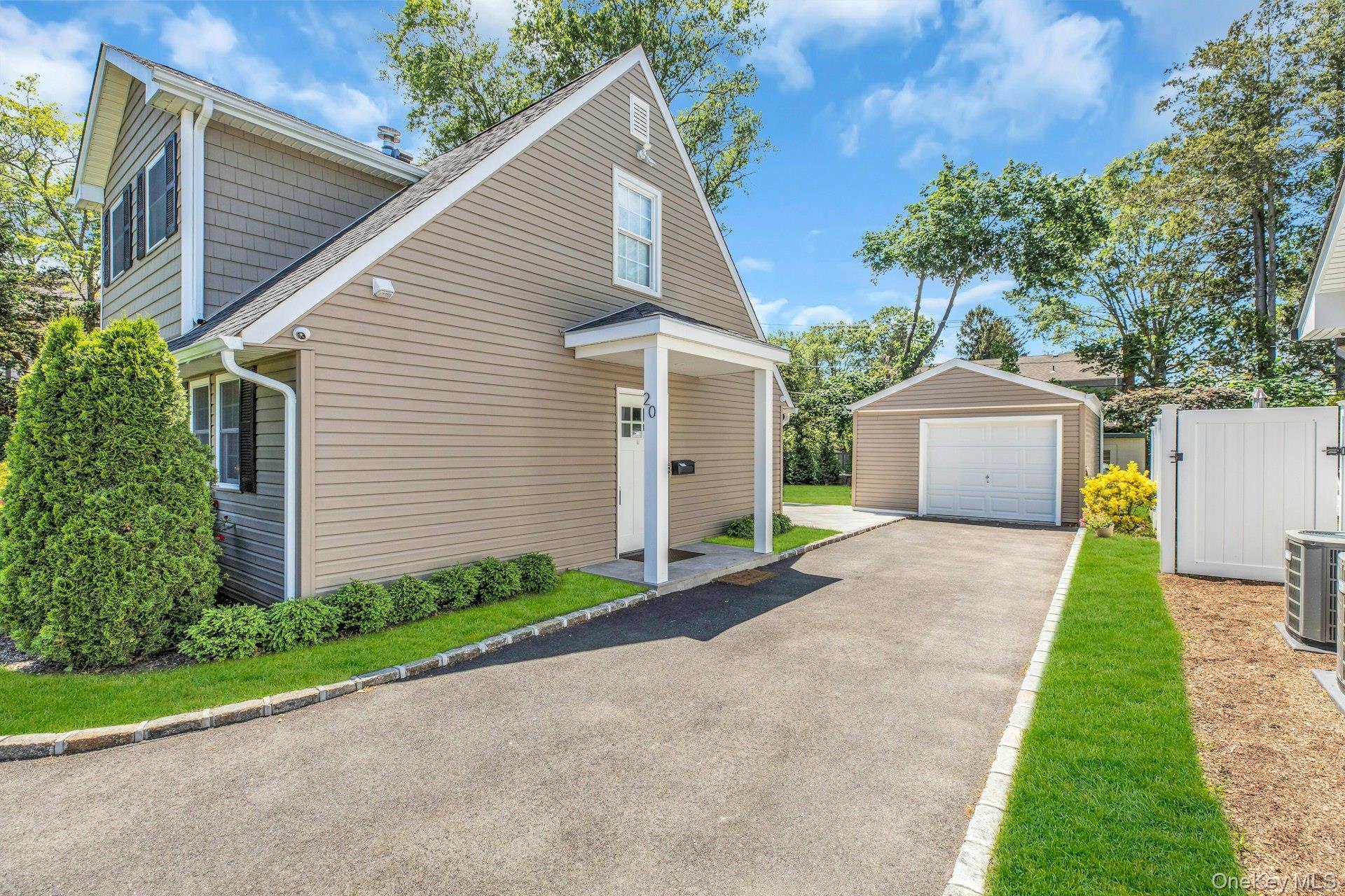 20 Robert Road Glen Cove, NY 11542 - Photo 22 of 24 a front view of a house with a yard and garage