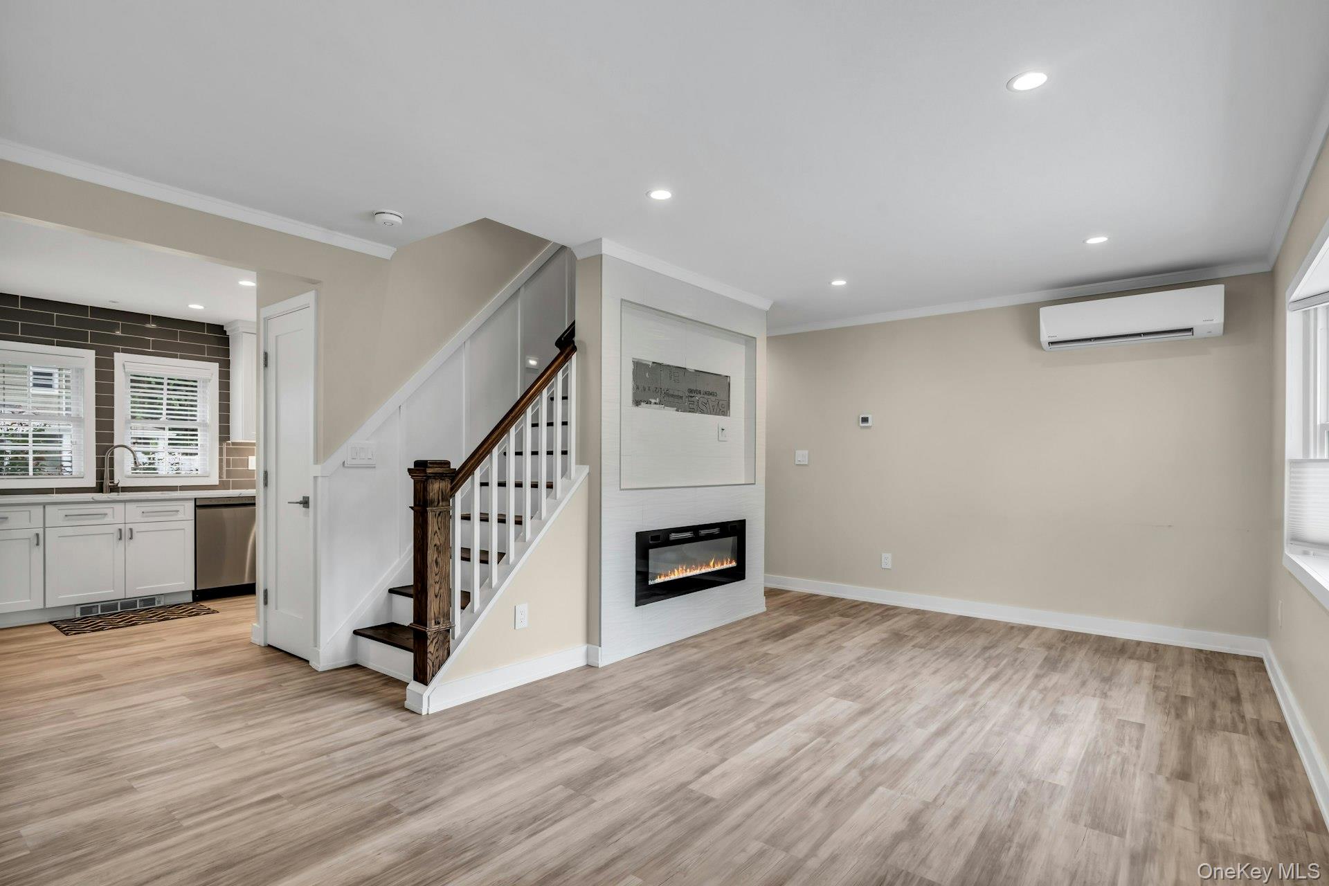 20 Robert Road Glen Cove, NY 11542 - Photo 3 of 24 a view of an empty room with wooden floor stairs and a kitchen