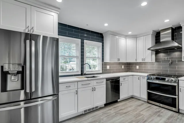 a kitchen with stainless steel appliances granite countertop a stove a sink and a refrigerator