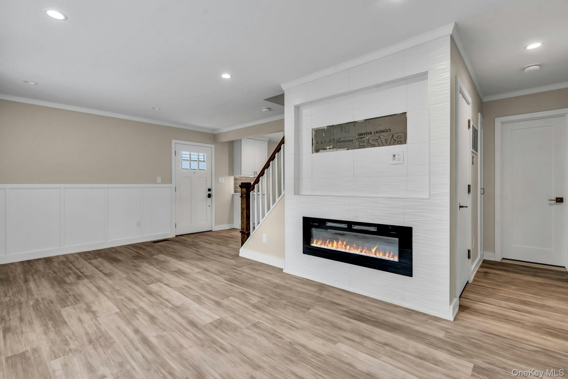 20 Robert Road Glen Cove, NY 11542 - Photo 5 of 24 an empty room with wooden floor fireplace and windows