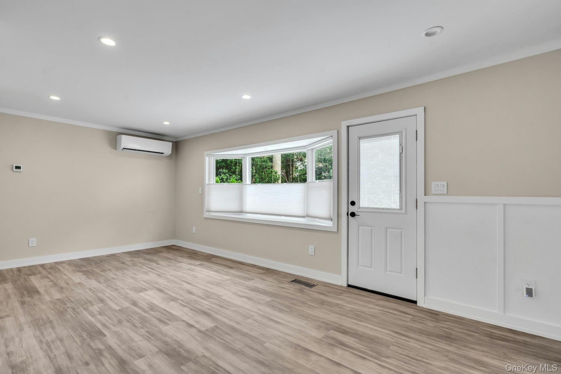 20 Robert Road Glen Cove, NY 11542 - Photo 6 of 24 an empty room with wooden floor and windows