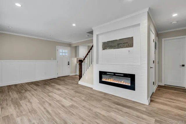 an empty room with wooden floor fireplace and windows