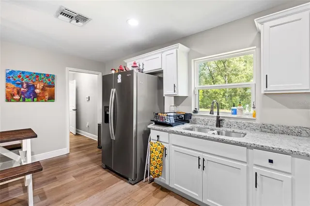 a living room with granite countertop furniture and a wooden floor