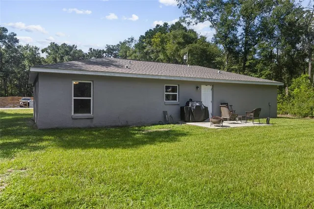 a view of a house with backyard and sitting area