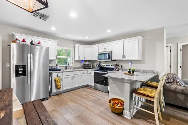 a kitchen with refrigerator and white cabinets