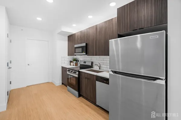 a kitchen with wooden cabinets and stainless steel appliances