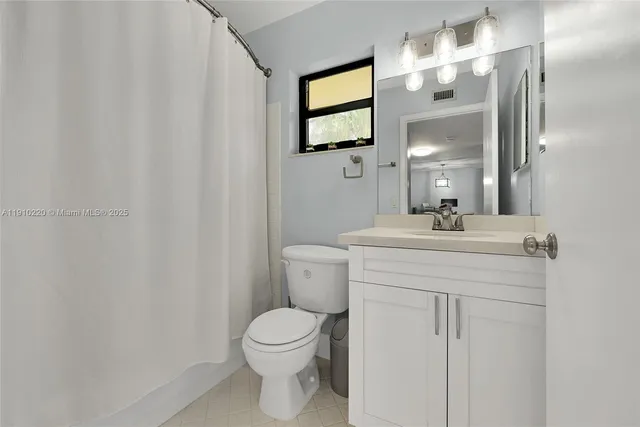 a bathroom with a sink a toilet and mirror