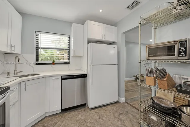a kitchen with stainless steel appliances a refrigerator sink and microwave
