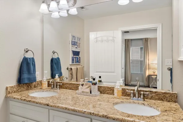 a bathroom with double vanity sinks and a mirror