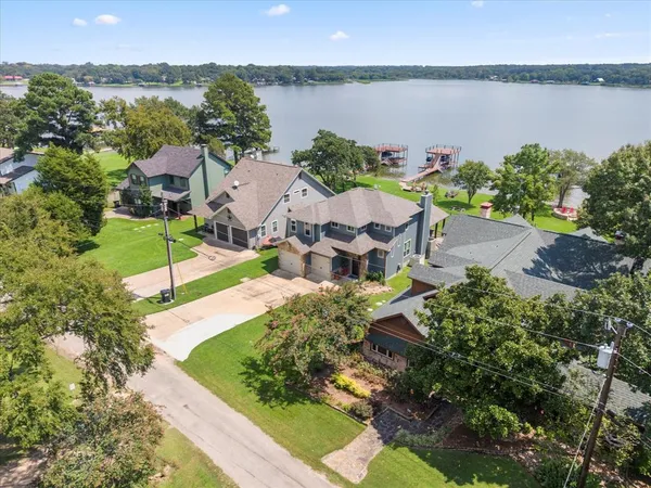 an aerial view of a house with a garden and lake view