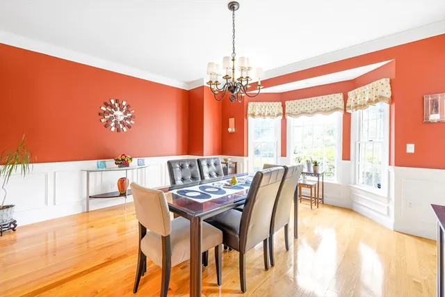 a dining room with furniture a chandelier and wooden floor