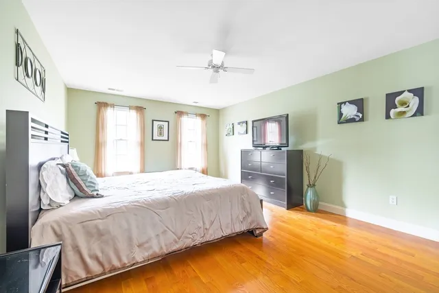 a bedroom with a bed wooden floor and window