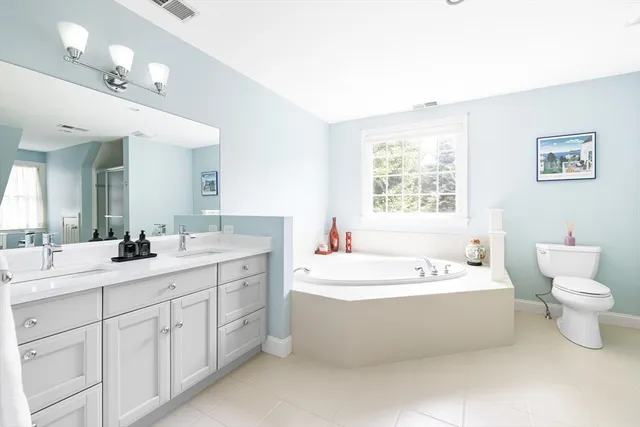 a spacious bathroom with a double vanity sink mirror and bathtub